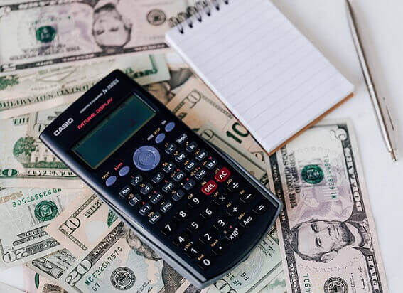 calculator and notepad on money to calculate damages in a dog bite case
